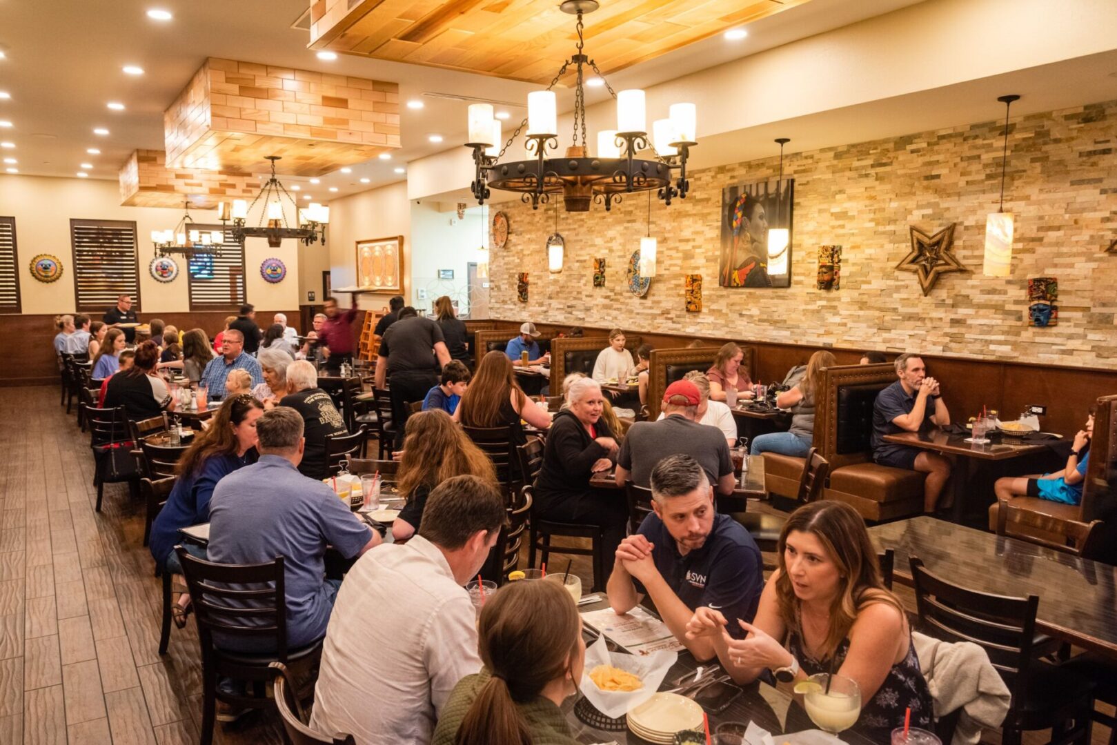 A group of people sitting at tables eating food.